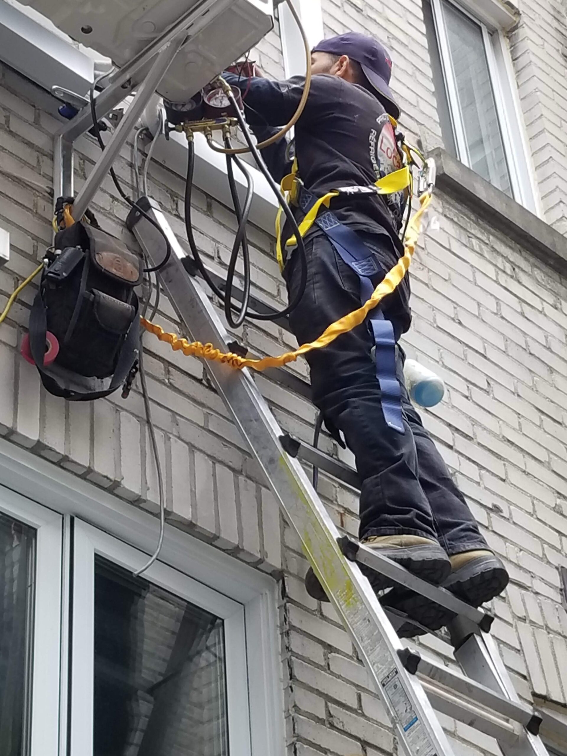 Technicien en train de détecter une fuite de réfrigérant sur une thermopompe extérieure à Montréal